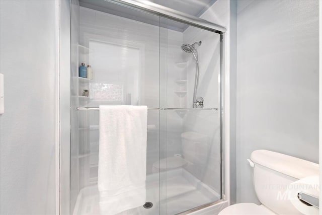 full bath with a stall shower and toilet