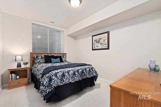 carpeted bedroom featuring baseboards and visible vents
