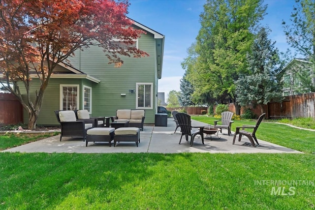 back of property with a fenced backyard, an outdoor living space with a fire pit, a patio area, and a yard