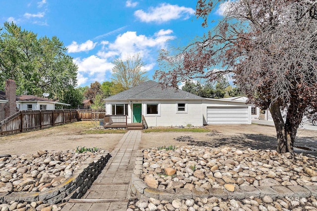 view of front of home with an attached garage, fence, driveway, and a deck