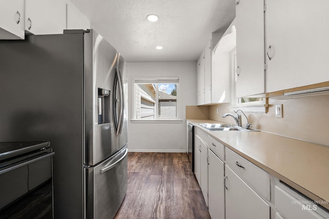 kitchen featuring a sink, light countertops, stainless steel fridge with ice dispenser, white cabinetry, and dark wood-type flooring