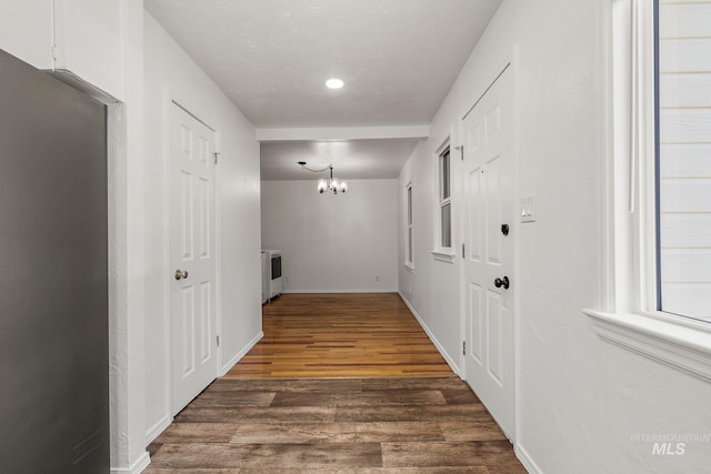 corridor featuring recessed lighting, baseboards, a notable chandelier, and dark wood-type flooring