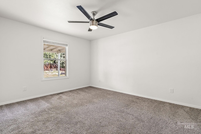 spare room with baseboards, carpet flooring, ceiling fan, and visible vents