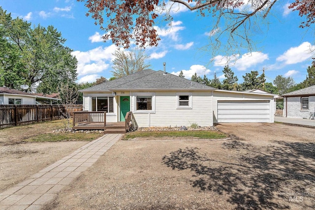 bungalow-style home with roof with shingles, fence, and a deck