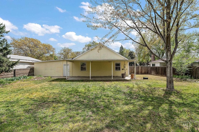 rear view of property with a patio, a fenced backyard, and a lawn