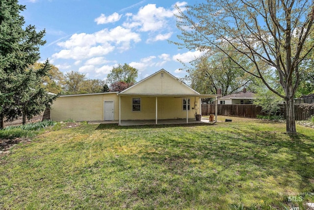 back of house featuring fence, a yard, and a patio area