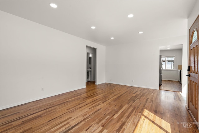 empty room with recessed lighting, baseboards, and wood finished floors