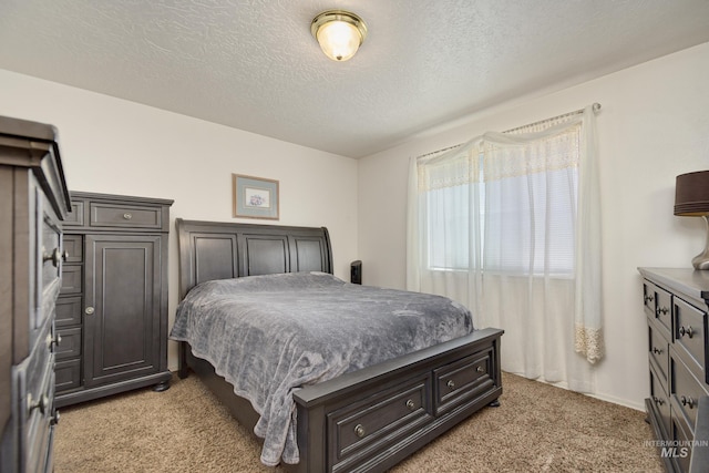 bedroom featuring a textured ceiling and light carpet
