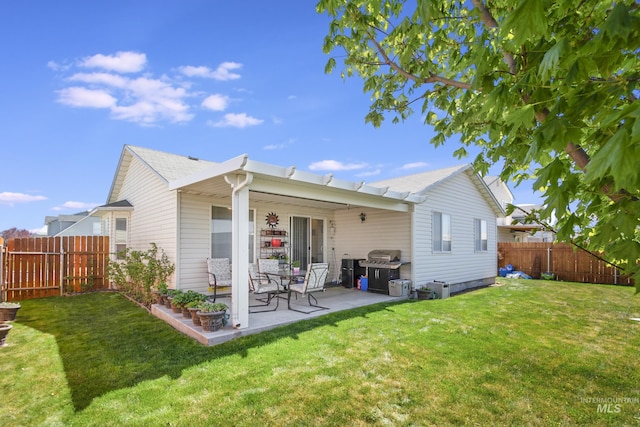 back of house featuring a lawn, a patio area, and a fenced backyard