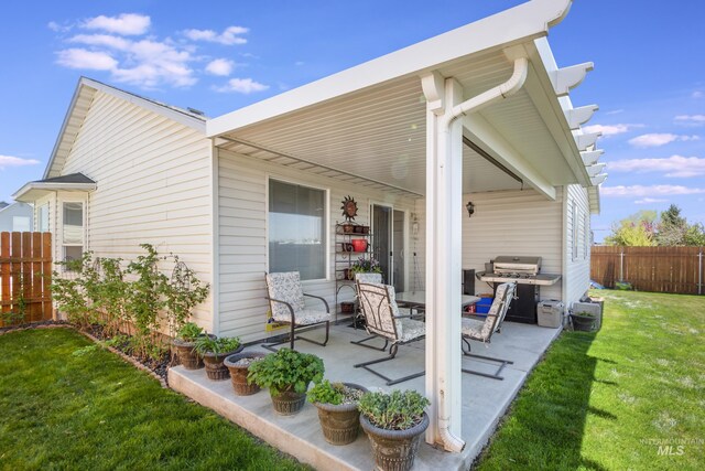 back of house featuring fence, a yard, and a patio