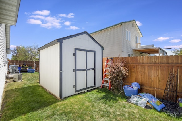 view of shed featuring a fenced backyard and central AC unit