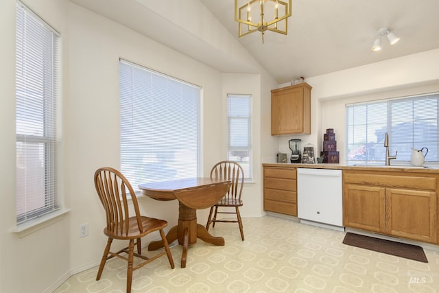 kitchen with white dishwasher, a sink, a chandelier, a healthy amount of sunlight, and lofted ceiling
