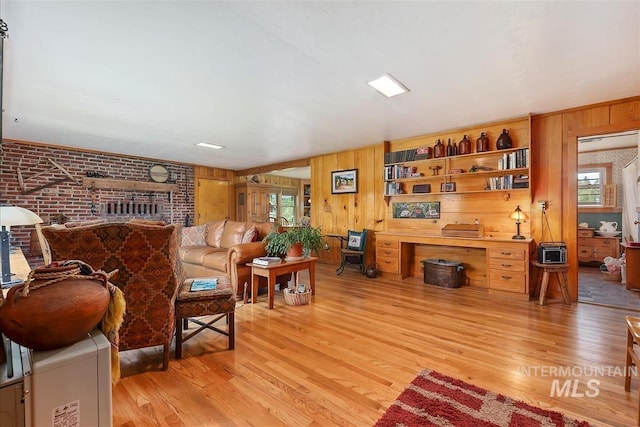 living room with light hardwood / wood-style floors and wood walls