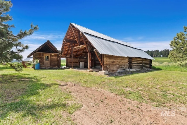 view of side of home featuring an outbuilding and a yard