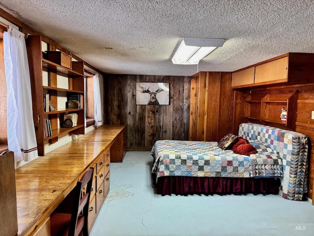 bedroom with a textured ceiling and wood walls