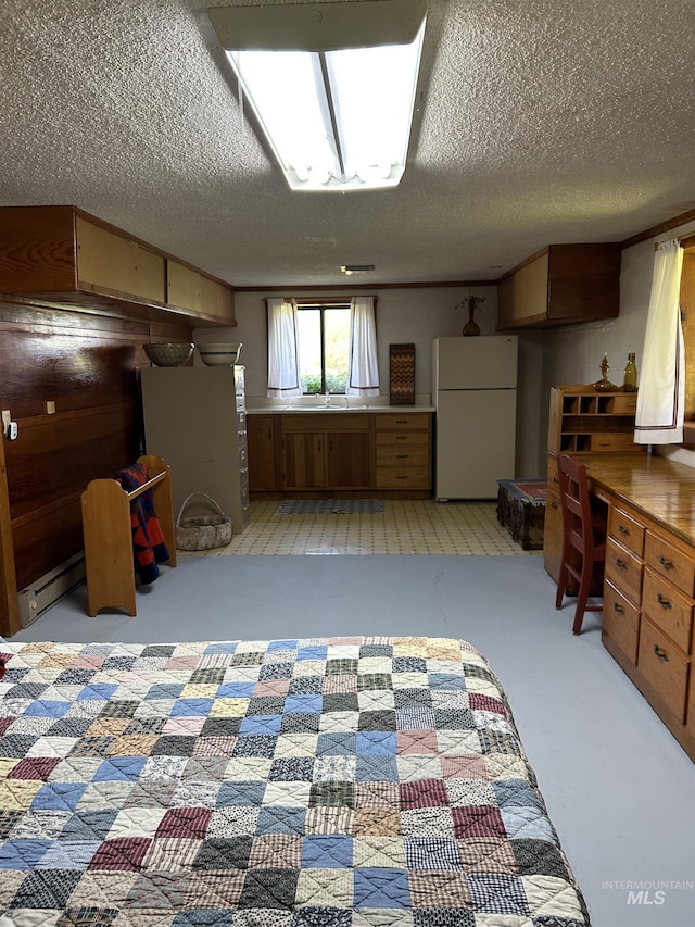 kitchen featuring white refrigerator, light carpet, and a textured ceiling