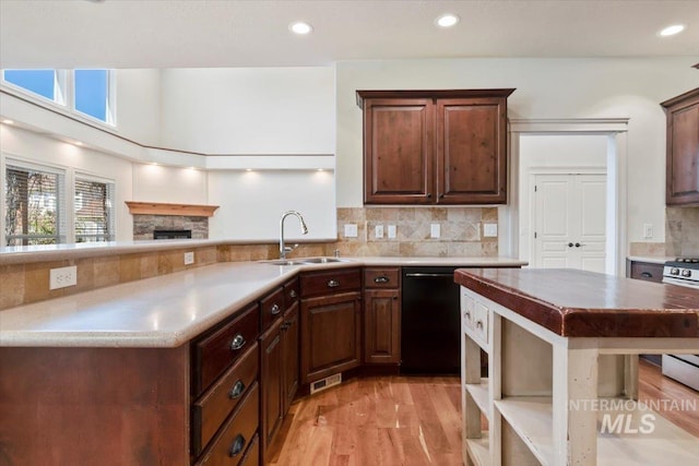 kitchen featuring light wood-type flooring, a sink, recessed lighting, and tasteful backsplash