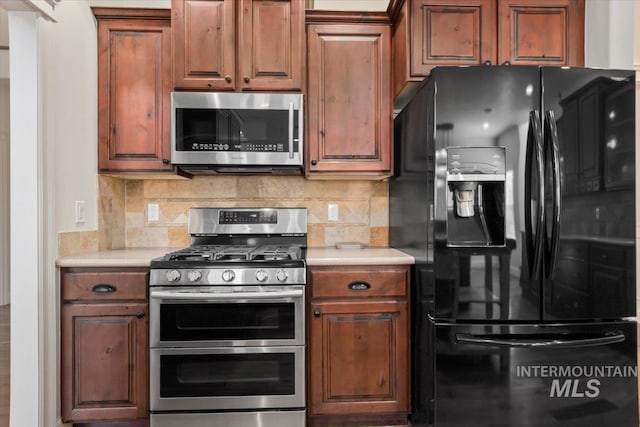 kitchen with light countertops, brown cabinets, appliances with stainless steel finishes, and tasteful backsplash