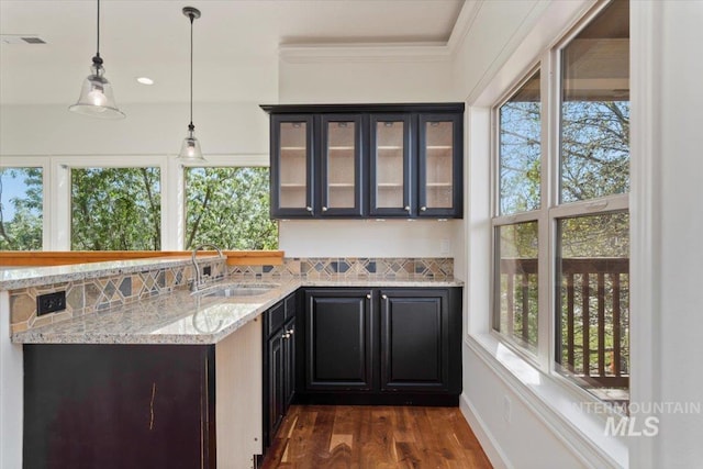 bar with dark wood finished floors, a wealth of natural light, a sink, and visible vents