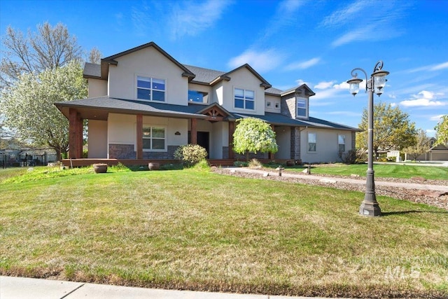 view of front of house featuring covered porch, stucco siding, stone siding, and a front yard