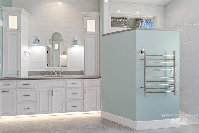 full bathroom with vanity, baseboards, and walk in shower