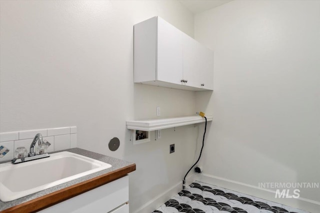 laundry room featuring baseboards, electric dryer hookup, a sink, cabinet space, and washer hookup