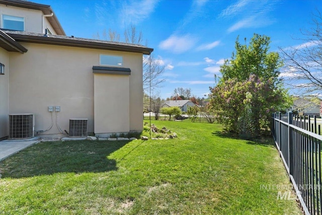view of yard featuring fence and central AC unit