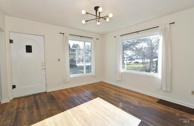 entryway featuring an inviting chandelier and dark hardwood / wood-style flooring