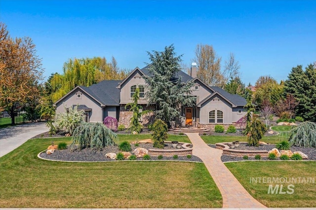 2246 W Crooked Stick Dr, Eagle, ID 83616 - view of front of house with stucco siding, a chimney, stone siding, and a front yard