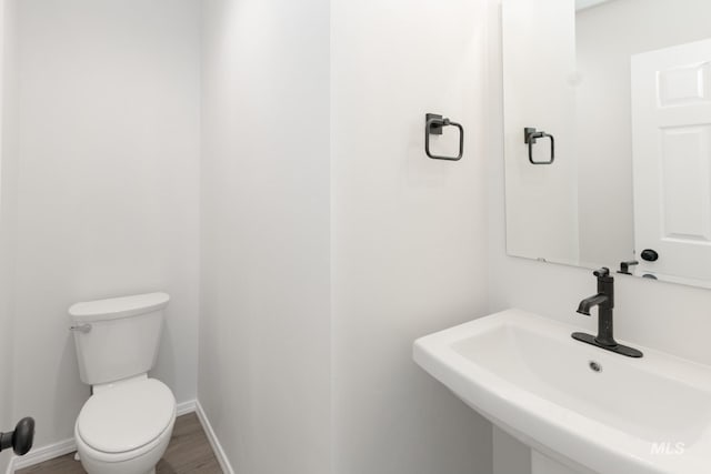 206 Marble Ave, Caldwell, ID 83605 - half bath featuring a sink, toilet, wood finished floors, and baseboards