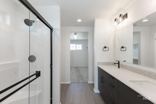 206 Marble Ave, Caldwell, ID 83605 - bathroom featuring wood finished floors, double vanity, a stall shower, baseboards, and recessed lighting