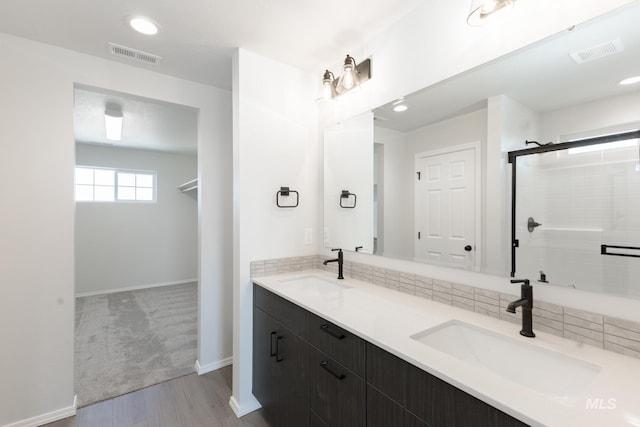 206 Marble Ave, Caldwell, ID 83605 - full bathroom with double vanity, wood finished floors, a tile shower, baseboards, and recessed lighting