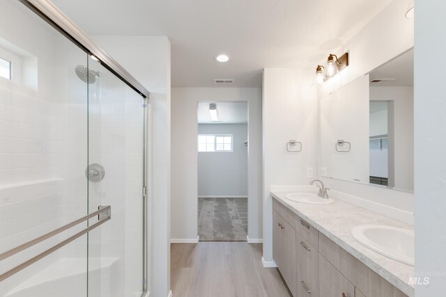 206 Marble Ave, Caldwell, ID 83605 - full bathroom with double vanity, a shower stall, wood finished floors, recessed lighting, and baseboards