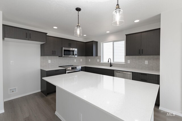 206 Marble Ave, Caldwell, ID 83605 - kitchen featuring appliances with stainless steel finishes, a sink, dark wood finished floors, light countertops, and tasteful backsplash