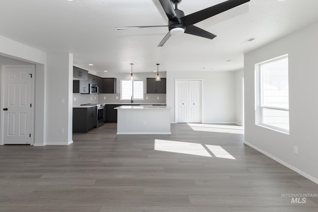 206 Marble Ave, Caldwell, ID 83605 - unfurnished living room featuring ceiling fan, wood finished floors, baseboards, and a sink