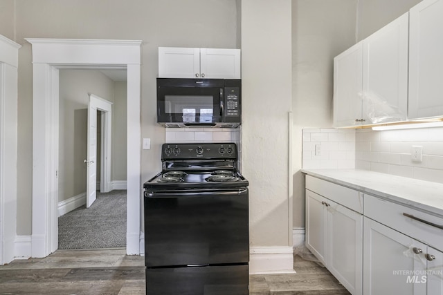 kitchen with backsplash, light carpet, black appliances, white cabinets, and light stone counters