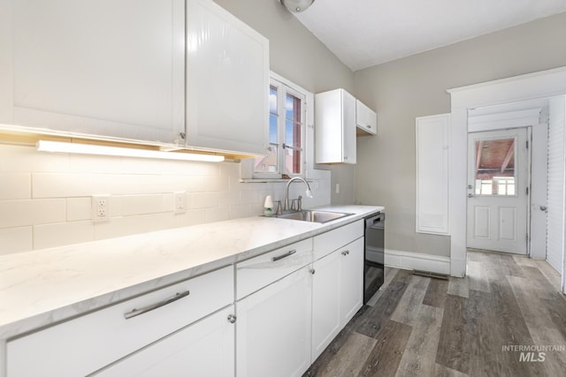 kitchen with white cabinetry, sink, dishwasher, dark wood-type flooring, and decorative backsplash