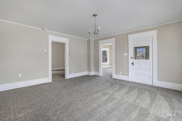 carpeted empty room with ornamental molding and a chandelier