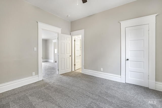 carpeted spare room featuring ceiling fan