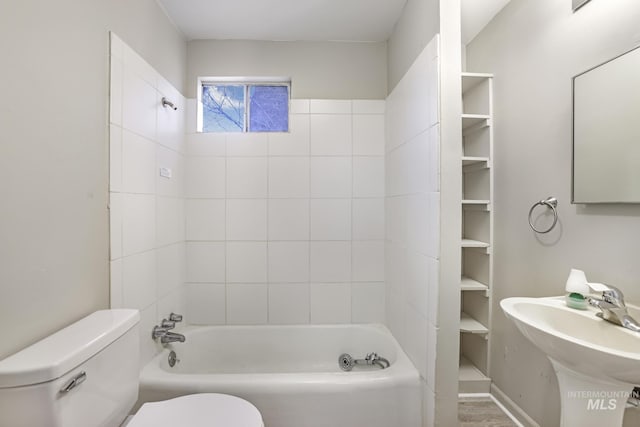 full bathroom featuring hardwood / wood-style flooring, sink, tiled shower / bath, and toilet