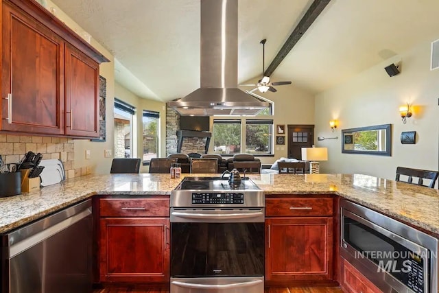 kitchen featuring kitchen peninsula, vaulted ceiling with beams, stainless steel appliances, and island range hood