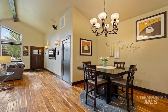 dining area featuring an inviting chandelier, beamed ceiling, high vaulted ceiling, and hardwood / wood-style flooring