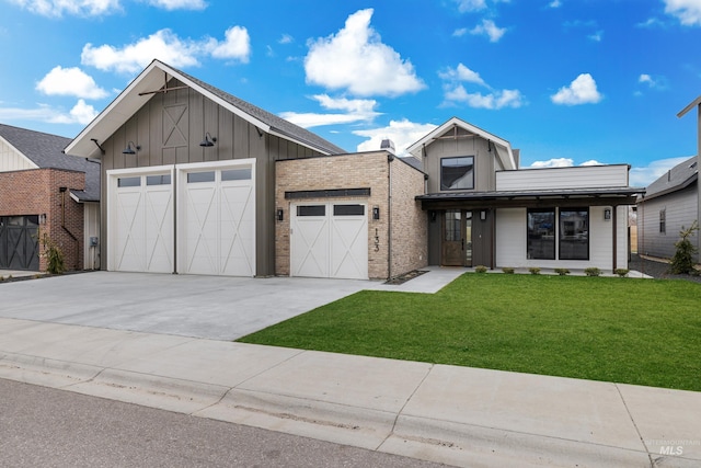 view of front of house featuring an attached garage, concrete driveway, a front lawn, and board and batten siding