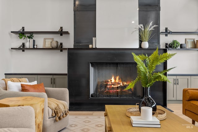 interior space featuring light tile patterned floors and a warm lit fireplace