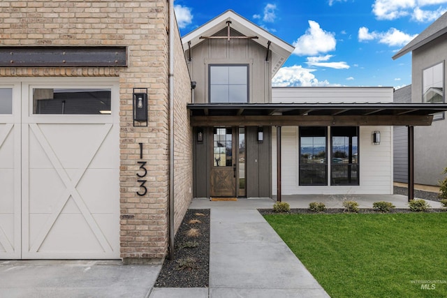 property entrance with a lawn and brick siding