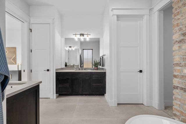 full bath with vanity, tile patterned floors, and baseboards