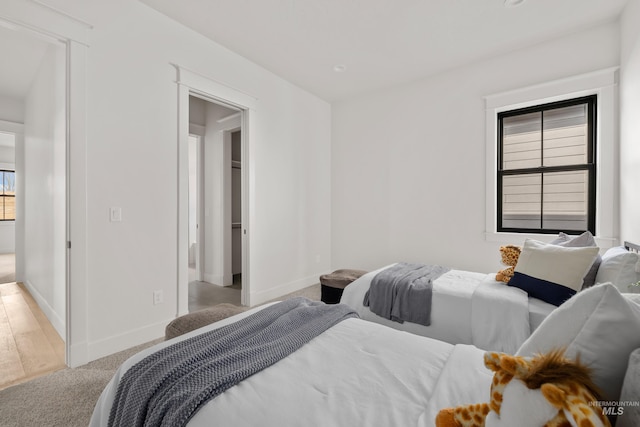 bedroom with light colored carpet and baseboards