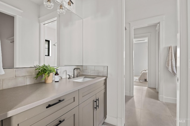 bathroom with tile patterned floors, baseboards, backsplash, and vanity