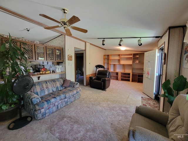 living room featuring ceiling fan, rail lighting, bar area, vaulted ceiling, and light carpet