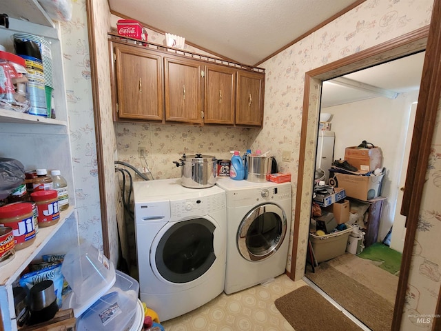 laundry area featuring washing machine and dryer, cabinets, a textured ceiling, and ornamental molding